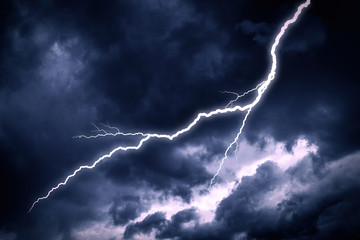 Lightning strike on a cloudy dark rainy sky.