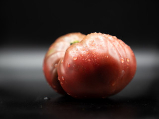 home grown red tomato isolated on black background