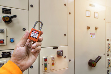 Red key lock and tag in hand for process cut off electrical,the toggle tags number for electrical...