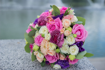 wedding rings on a wedding bouquet on the background of the river