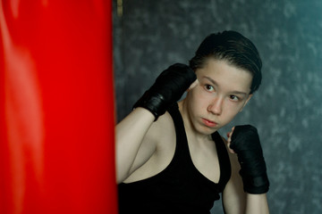 A teenager in a black t-shirt in Boxing training.