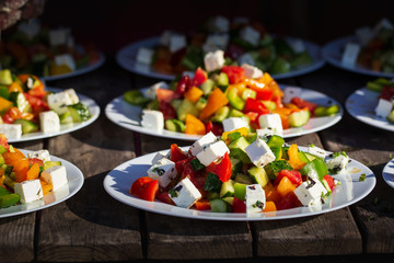 Greek salad of fresh cucumber, tomato, sweet pepper, lettuce, red onion, feta cheese and olives with olive oil. Healthy food,