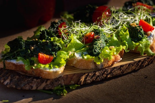 Close up bruschetta with proschuto, tomato, parmesan cheese and arugula
