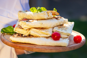 Shaurma, shaurma doner, meat with vegetables in a bread cake, on a light stone or concrete background. Concept restaurant fast food. Catering.