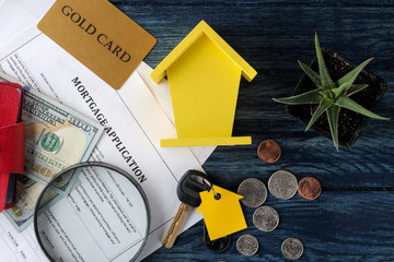 mortgage application. Key with house keychain and blank and money on a blue wooden table. concept of buying a home. top view