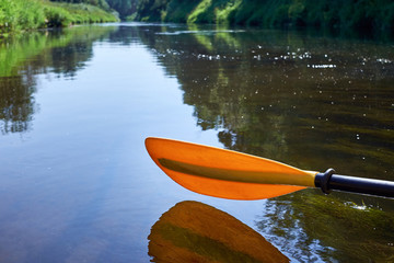 Yellow paddle close up.Yellow paddle over the water. © Alvydas