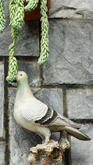 Cityscape with a dove sculptures and green plants beside the wall, traditionally dove is a peaceful symbol, an image for for background, copy space, web banner, texture, wallpaper, backdrop usage.