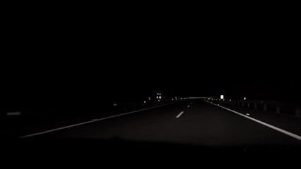 4K, POV view of car driving on road of highway at night in Spain. Drive on an empty road in the dark evening. A car drives on a freeway. Asphalt with white line at new road.-Dan