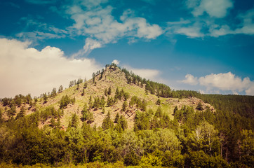 Beautiful mountain peak in clouds Sunset with rocks and pine forest