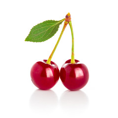 red cherry with green leaves on a white background.