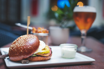 Burger with french fries and beer on a table in a cafe