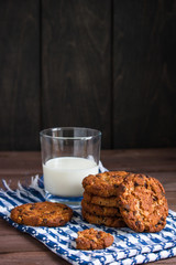 glass of milk chocolate cookies stack on wooden table vertical orientation