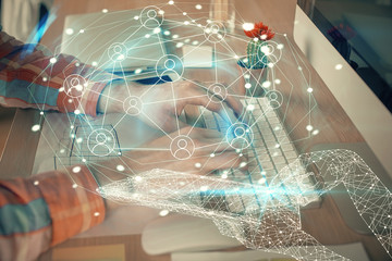 Social network theme hologram with businessman working on computer on background. Concept of world...