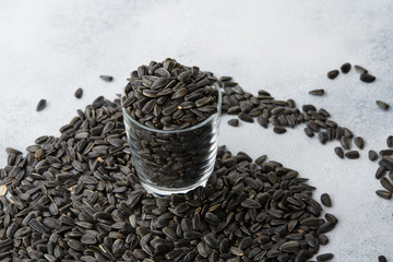 Unpeeled sunflower seeds in a glass on the table. Close-up