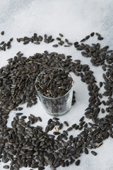 Unpeeled sunflower seeds in a glass on the table. Top view.