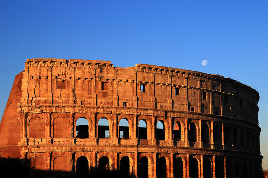 The Colosseum in Rome seen from the east, under the moon and lit up by a soft January morning light