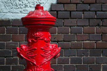 ornate old fire hydrant against the brick wall