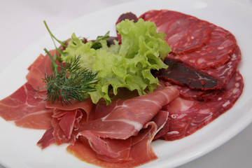  Assortment of spanish tapas or italian antipasti, jamon, prosciutto, chorizo, salami. Closeup assorted from meat