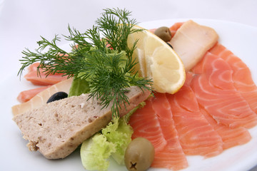  cold fish platter on a white plate close-up. pieces of different fish