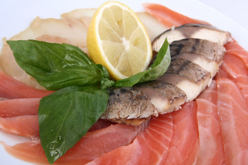  cold fish platter on a white plate close-up. pieces of different fish