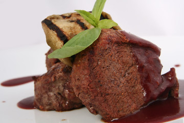  grilled meat with grilled vegetables in sauce closeup