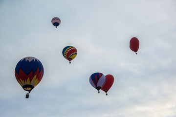 Multicolored hot air balloons on a blue cloudy sky