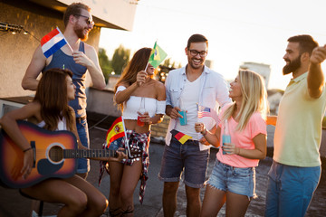 Group of carefree friends dancing have fun in summer