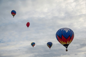 Multicolored hot air balloons on a blue cloudy sky