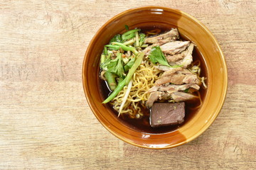 egg noodles with boiled duck in Chinese herb brown soup on bowl