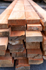 a pile of wooden planks lying on the street. wooden building material. A lot of wooden planks lying on the ground. Wooden sticks are lying on the ground. lumber lying on the street. Pine board cut