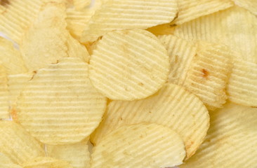 close up of crispy salt potato chips on white background