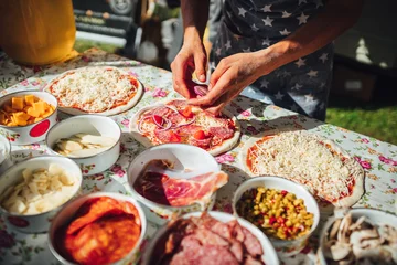 Fotobehang Male chef preparing dough for pizza in outdoor market. Street food. © Aleksandrs Muiznieks