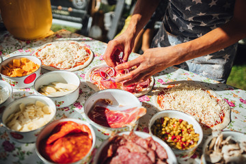 Male chef preparing dough for pizza in outdoor market. Street food.