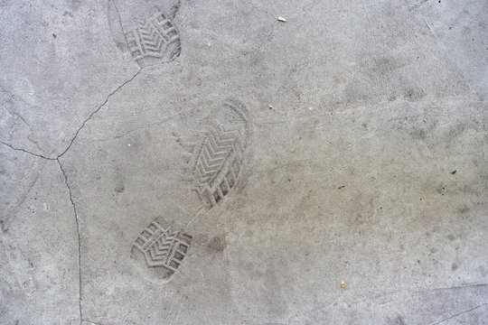 traces of shoes on the concrete floor. Imprints of shoes on the concrete floor. Shoe markings left behind in wet cement by contractor's reckless workmen. Shoe prints background