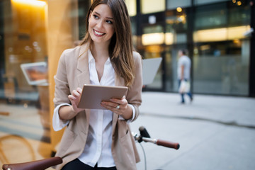 Urban happy business woman using tablet computer and working