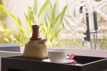 Teapot and teacups on the tray next to the bathtub, a day at the spa, wellness and wellbeing concept