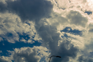 White compact clouds with small cuts of the blue sky; Against the background of clouds of bright shades and also dark closer to cloudy are strongly noticeable.