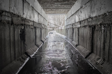 Exit from the drainage sewage rectangular  tunnel. Empty concrete Drainage collector of city sewage system