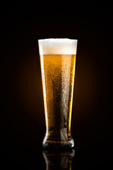 Glass of beer on black background