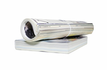 Magazine roll and book on white background.