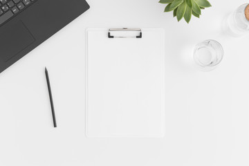 Top view of a white clipboard mockup with  workspace accessories, laptop and a succulent plant on a white table.