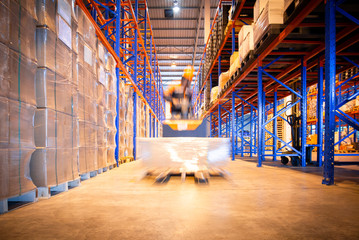 Blur Motion of Workers Driving Forklift Unloading Cargo Pallets in The Warehouse. Shipping...