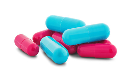 Pile of medical pills in red and blue colors on white isolated background with shadow.