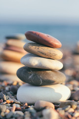 Balance pyramid from sea stones on blurred background. Calm and rest place on the beach. Zen garden. 