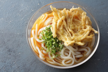 透明なガラスの器に入ったごぼう天入りのざるうどん