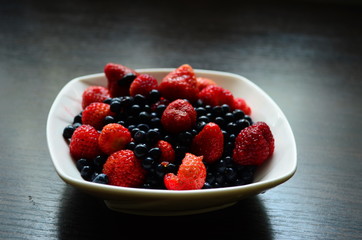 strawberries and blueberries in a plate on the table