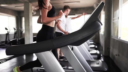 Strong men and women are running jogging on the treadmill happily, the gym concept and bodybuilding.