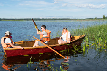 family riding a wooden boat on the lake in good weather