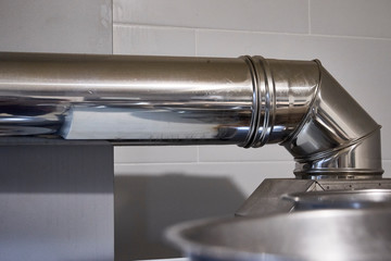 Steel stainless aluminum silver big rounded oven pipes heat steam ventilation protection. Professional clean modern industrial restaurant kitchen.