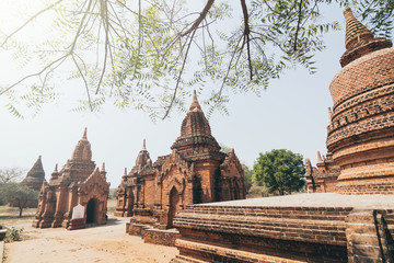 Fototapeta premium View over stupas and pagodas of ancient Bagan temple complex during sunrise golden hour in Myanmar